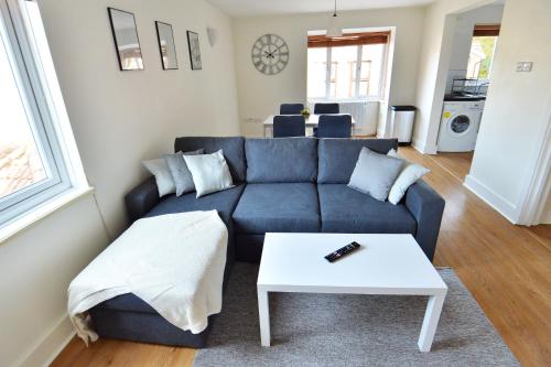 克劳利Luxury 2 BR Fully Furnished Flat in Crawley - 2 FREE Parking Spaces的客厅配有蓝色的沙发和桌子