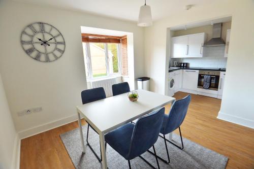 克劳利Luxury 2 BR Fully Furnished Flat in Crawley - 2 FREE Parking Spaces的一间带桌椅和时钟的用餐室