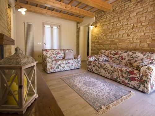 法诺Belvilla by OYO Villa Vanessa Coccinella的客厅设有两张沙发和砖墙