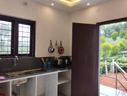 瓦加蒙SHI's Vagamon Hill Retreat- Private villa on Hills的厨房配有黑色台面和窗户