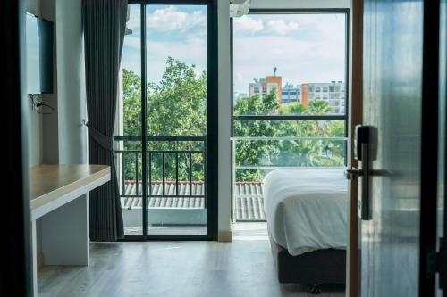 Ban Nong WaengGoodday Hotel的一间卧室设有一张床,享有阳台的景色