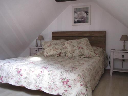 希伯维列Le Bretzel的一间卧室配有一张带花卉床罩的床