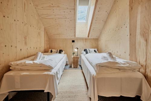 史特林Lodgen Stryn的木墙客房的两张床