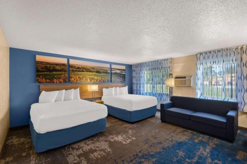 牛顿牛顿戴斯酒店的酒店客房,设有两张床和一张沙发