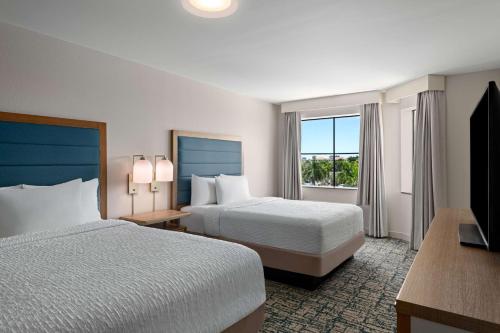 西棕榈滩西棕榈滩希尔顿惠庭套房酒店的酒店客房设有两张床和电视。