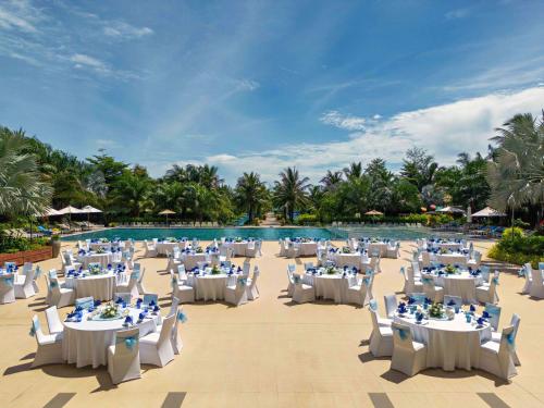 富国Best Western Premier Sonasea Phu Quoc的游泳池前带桌椅的婚礼场地