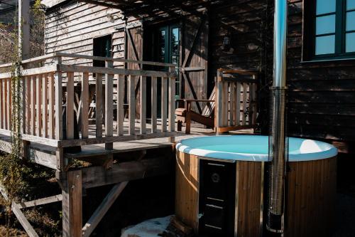 BusserollesLa ferme du pont de Maumy, cabane au bord de l'étang et bain nordique的小屋甲板上的热水浴池