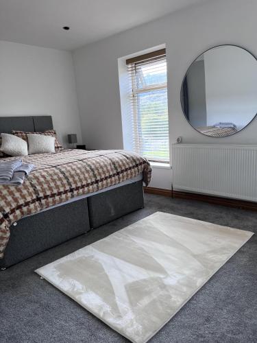埃布韦尔Modern Newly Renovated 3 Story House in Ebbw Vale的一间卧室配有床、镜子和地毯