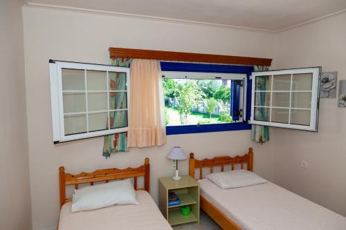 瓦西利卡Liakos' Apartments的带2扇窗户的客房内的2张床