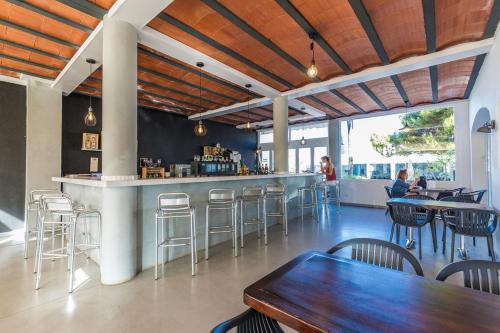 萨卡莱塔Vibra Caleta Playa Apartmentos-3SUP的餐厅设有酒吧,配有桌椅