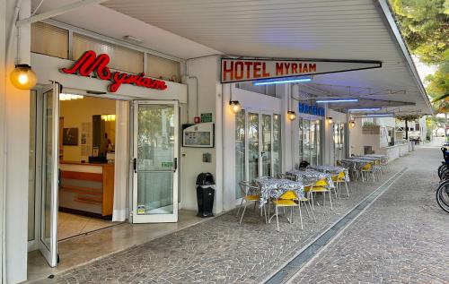 利尼亚诺萨比亚多罗Hotel Myriam的街边设有桌椅的餐厅
