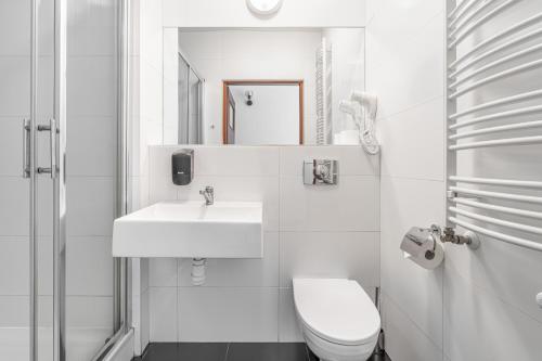 乌涅尤夫Dom Pracy Twórczej的白色的浴室设有卫生间和水槽。