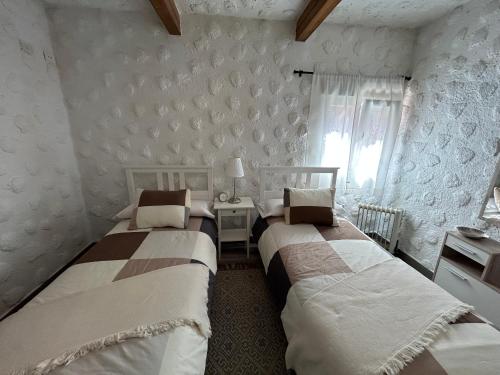 圣克鲁斯-德特内里费Casa Rural Juli的一间卧室设有两张床、一张桌子和一个窗口