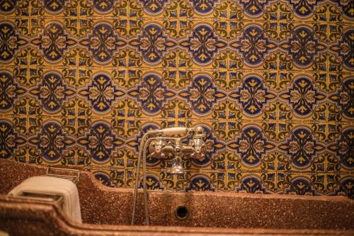 查兹拉德拉谢拉圣贝尼托宫酒店的浴室设有金色和蓝色图案的墙壁