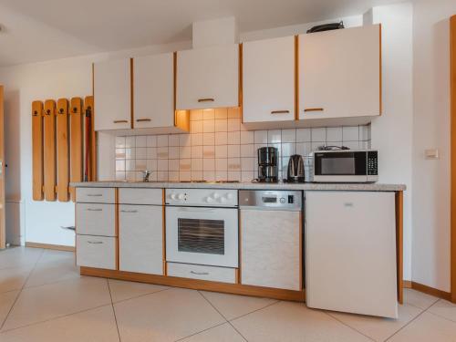 克尼格利斯滕Apartment Voithofer-1 by Interhome的厨房配有白色家电和白色橱柜