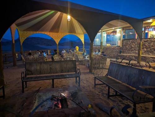 瓦迪拉姆Desert Magic Camp & Resort的一群长椅,在帐篷里,火烧