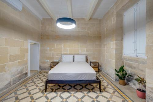 斯利马Seafront Traditional Maltese Townhouse Balluta Bay的卧室配有砖墙内的床铺
