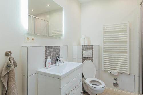 汉堡Hanseat Apartments的白色的浴室设有卫生间和水槽。