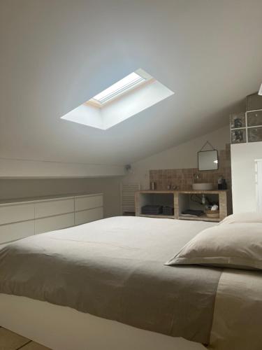 Grosseto-PrugnaCasa San Carlu的白色卧室设有一张带天窗的大床