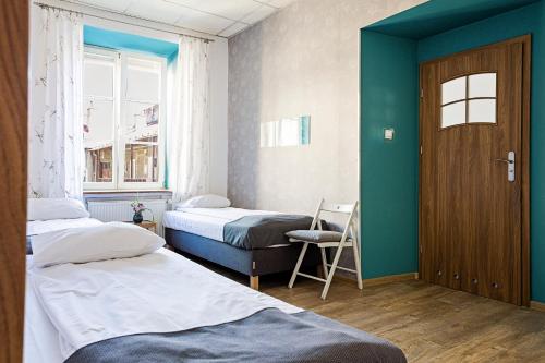 卢布林民俗旅舍的客房设有两张床、一扇门和一扇窗户。