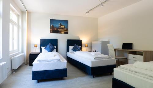 汉堡Hanseat Apartments的一间卧室配有两张床和一张书桌