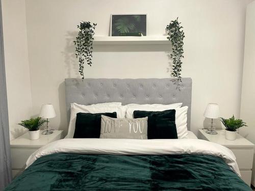 布里斯托Stockwood Apartment by Cliftonvalley Apartments的一间卧室配有一张带绿色棉被和植物的床