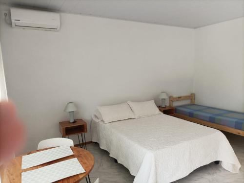 圣安娜La Residenza的白色卧室配有床和桌子