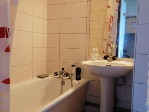 拉普德兹Appartement Huez, 2 pièces, 4 personnes - FR-1-405-138的浴室配有盥洗盆、浴缸和盥洗盆