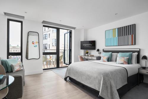 布莱顿霍夫Q Square by Supercity Aparthotels的一间卧室配有一张床、一张桌子和一面镜子