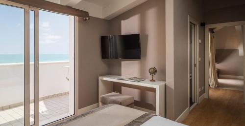 里乔内玛耶斯塔雷酒店的一间卧室设有一张床、一台电视和一个窗口。