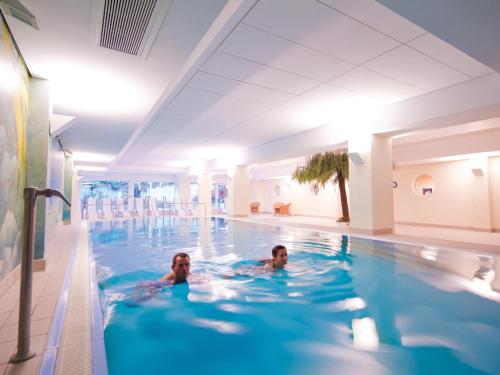 奥斯赛拜-屈隆斯博恩库隆斯博恩莫拉达度假酒店的在游泳池游泳的人