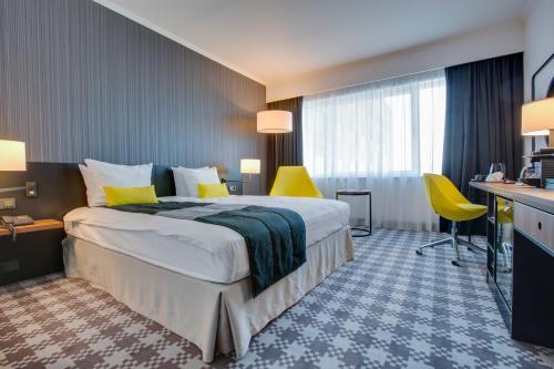 史基浦Radisson Blu Hotel Amsterdam Airport, Schiphol的酒店客房设有一张大床和黄色椅子。