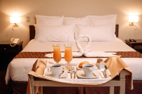 利马Hotel Carrera的床上的托盘,上面放着两杯橙汁