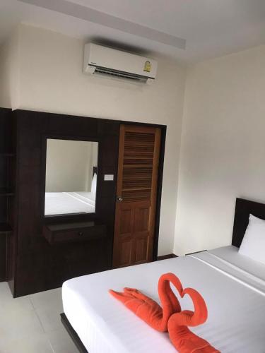 甲米镇Hassana Apartment的两个红色天鹅在房间里床上