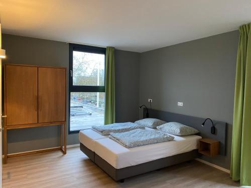 瓦赫宁根Short Stay Wageningen的一间卧室设有一张床和一个大窗户