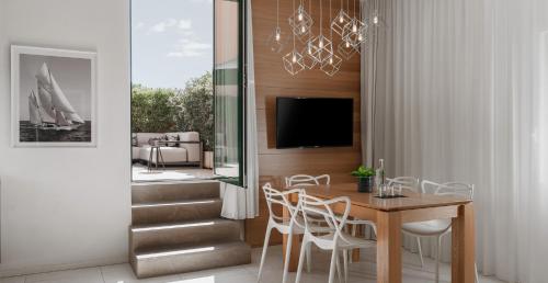 里乔内Metropol Ceccarini Suite - Luxury apartments的一间带桌椅和电视的用餐室