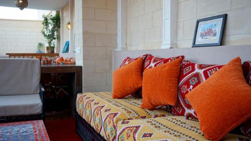 马拉喀什RIAD KALE POLIS的一张床上的橙色枕头
