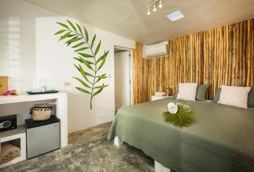 喀巴里特El Encuentro Surf Lodge的一间卧室,配有绿床,上面有植物