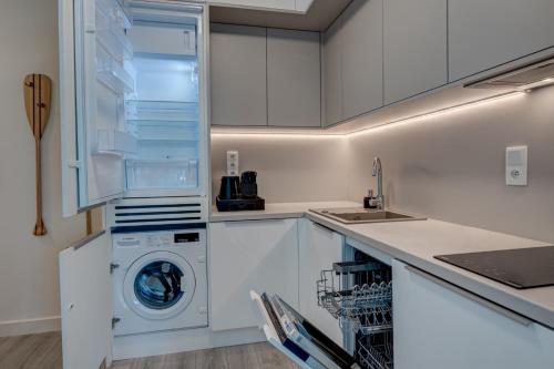 米兹多洛杰Privilege Apartment的白色的厨房配有洗衣机和烘干机