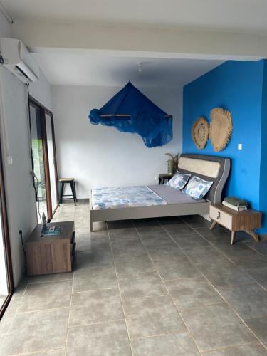 Acouala maison du nord的一间卧室设有一张床和蓝色的墙壁