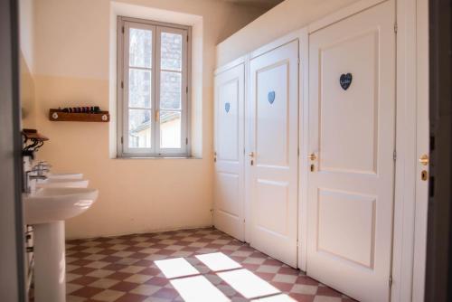 卡麦奥雷Ostello di Camaiore的一间带水槽和白色门的浴室