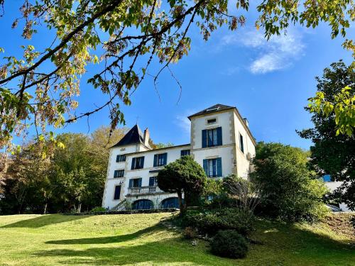 保拉扎克Richard Lequet Domaine gastronomique du Val d Atur的一座树木茂密的山丘上的白色大建筑