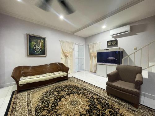 卢穆特Venice Raudhah Guest House的带沙发、椅子和电视的客厅