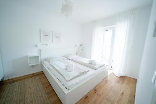 赖弗尼茨Apartment Seekind by Cosy Homes的白色的卧室设有白色的床和窗户。