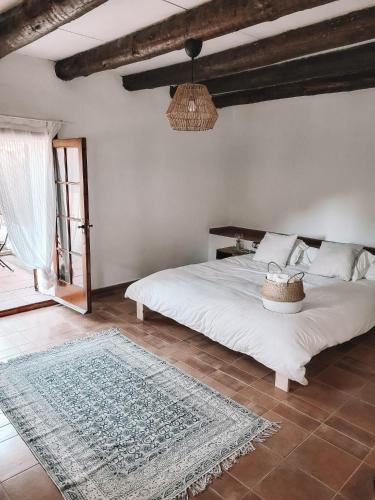 DosríusCasa Om的卧室配有白色的床和地毯。