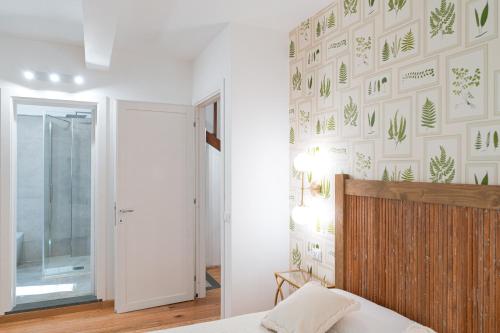 巴尼奥雷焦Acqua di Civita Beauty & Rooms IL PONTE的卧室拥有白色墙壁,上面有绿色植物