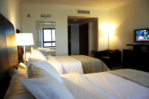 罗萨里奥罗斯大厦酒店的酒店客房设有两张床和电视。