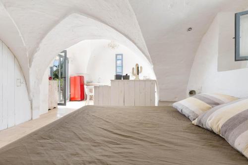 圣维托诺曼Lamia Madreperla by BarbarHouse的一间白色客房内的床铺卧室