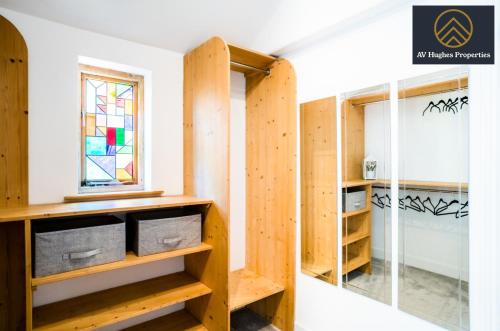 北安普敦Elegant Two Bedroom House by AV Hughes Properties Short Lets & Serviced Accommodation Northampton with Free Parking & Fast Wi-Fi的一间设有木制架子和窗户的房间