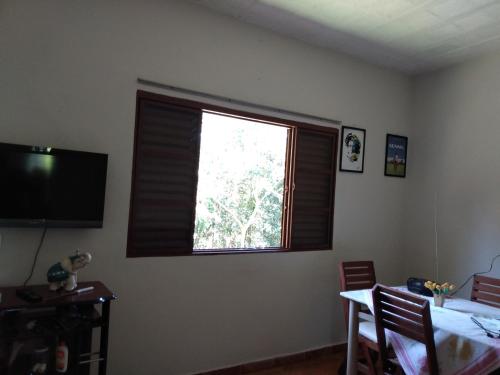 圣若昂-达巴拉Rancho Belo的窗户位于带桌子和用餐室的客房内